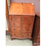 A reproduction mahogany bureau the fall front over serpentine drawers