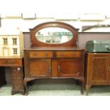 An early 20th century walnut mirrored back sideboard with two drawers over two cupboard doors on