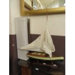 A wooden model of a Yacht on a stand