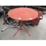 A red painted folding metal bistro table