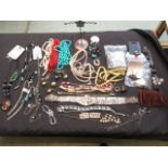 A bag containing a large quantity of costume jewellery to include bangles, beads etc.