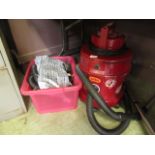 A red Vax vacuum cleaner with attachments