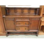 An early 20th century oak sideboard having three drawers flanked by cupboard doors