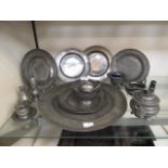 A collection of pewter plates, tea set etc.