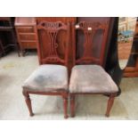 A pair of Edwardian walnut side chairs having over stuffed seats