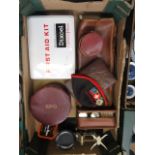 A box containing an early 20th century first aid kit, leather collar box, scales,