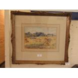A framed and glazed watercolour of harvest scene signed bottom left