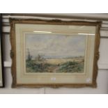 A framed and glazed watercolour of countryside scene signed E.