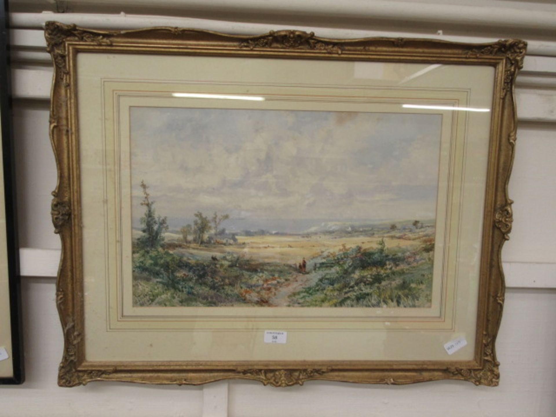 A framed and glazed watercolour of countryside scene signed E.