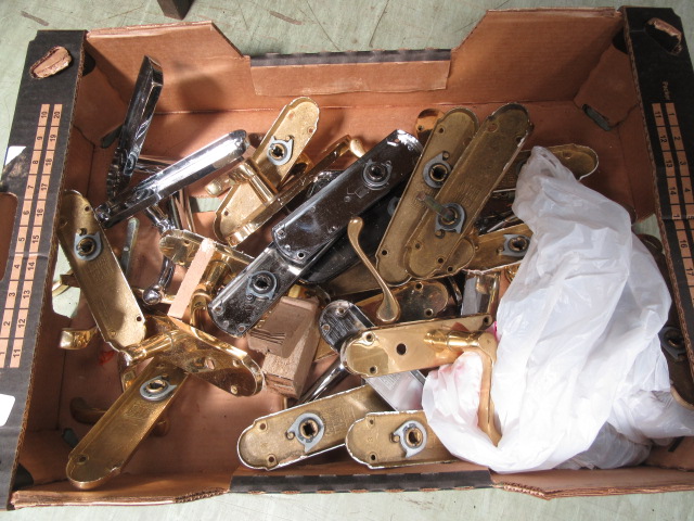 A box containing an assortment of door handles and latches