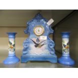 A blue ceramic mantle clock with bird design together with an pair of matching candle sticks