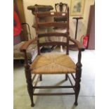 An early 20th century oak framed open armchair with seagrass seat