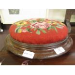 A Victorian walnut footstool with floral needlework upholstery