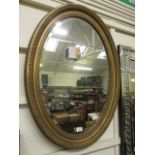 A gilt framed oval bevel glass mirror