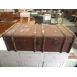 An early 20th century hessian wood and metal bound travelling trunk