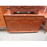 A mid 20th century sideboard having three drawers with doors below
