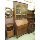 An early 20th century bureau bookcase, two lead glass doors over fall front, single drawer,
