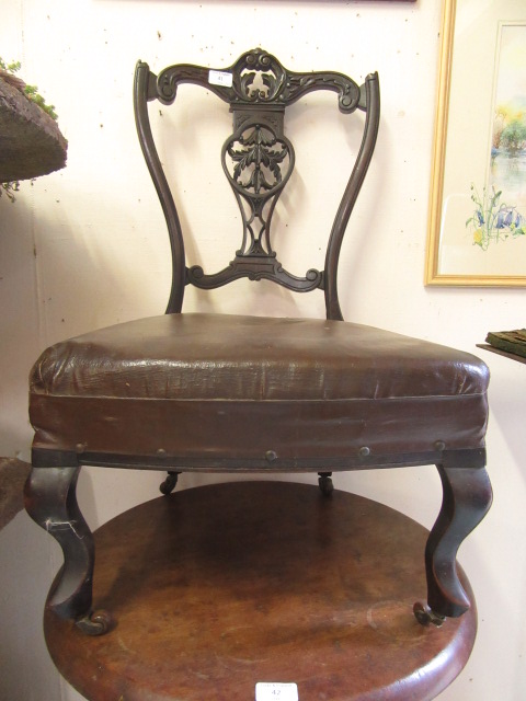 An Edwardian mahogany bedroom chair having carved and pierced top rail on cabriole legs