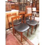 A set of four mid 20th century teak dining chairs with black vinyl seats