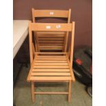 A pair of modern beech effect folding chairs