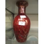 A red and gold glittered glass vase