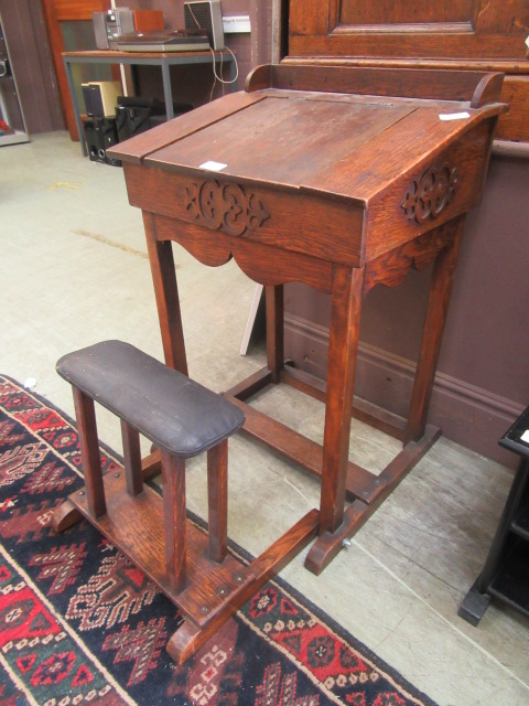 An early 20th century oak school desk with fold out seat and lift up slope