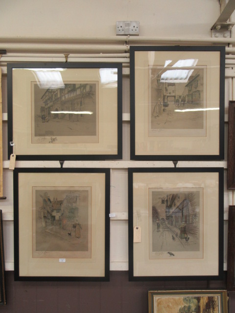 A set of four framed and glazed prints of town scenes signed Cecil Aldin with blind stamp