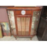 An early 20th century walnut veneered display cabinet incorporating clock to top center
