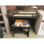 A Technics electric organ with stool and books