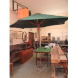 A green canvas garden parasol on stand and base