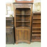 A reproduction oak floor standing corner cupboard