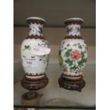 A pair of reproduction oriental ceramic vases on wooden bases