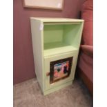 An upcycled mid-20th century bedside cabinet having open storage above a hand painted panelled door