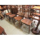 A set of four wheel back dining chairs