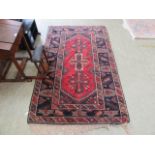 A hand woven north Persian rug triple line border enclosing a red ground field