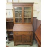 An early 20th century bureau bookcase, two lead glass doors over fall front, single drawer,