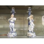 A pair of continental blue and white candle sticks having boy and child decoration