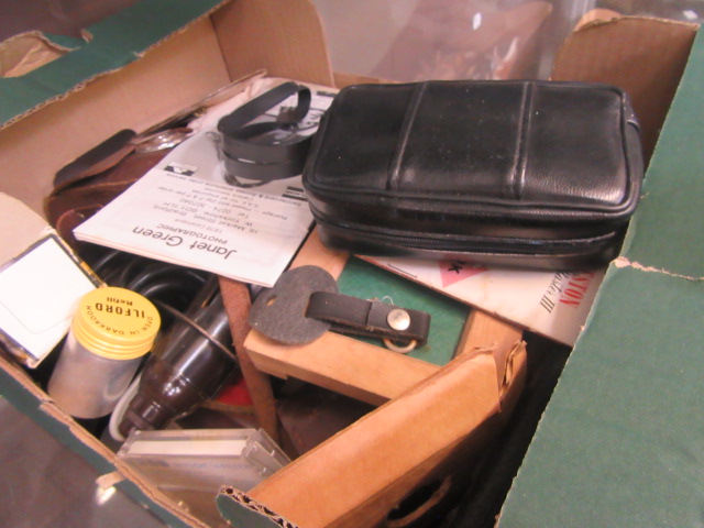 A box containing an assortment of photographic cameras and other equipment