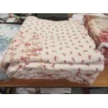 Two cream and red floral bed throws