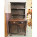 An early 20th-century stained pine dresser with a plate rack over two drawers and two cupboard