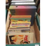 A tray containing three folios of sheet music, children's annuals,