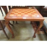 An Indonesian hardwood games table with ball and claw feet
