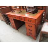 A reproduction yew twin pedestal desk