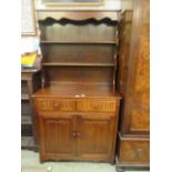 A modern oak dresser with a plate rack over two drawers and two linen fold cupboard doors