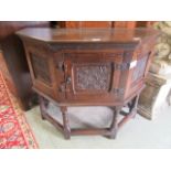 A reproduction 17th-century style oak table cabinet with carved panels