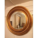 A very large gilt framed circular bevel glass mirror with rope twist design