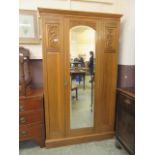 An early 20th-century walnut single glazed door wardrobe