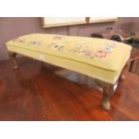 An early 20th century foot stool with yellow floral needle work seat on cabriole legs