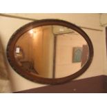 An early 20th century oak framed oval bevelled glass mirrror