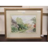 A framed and glazed watercolour of village scene signed Margaret Wilkins